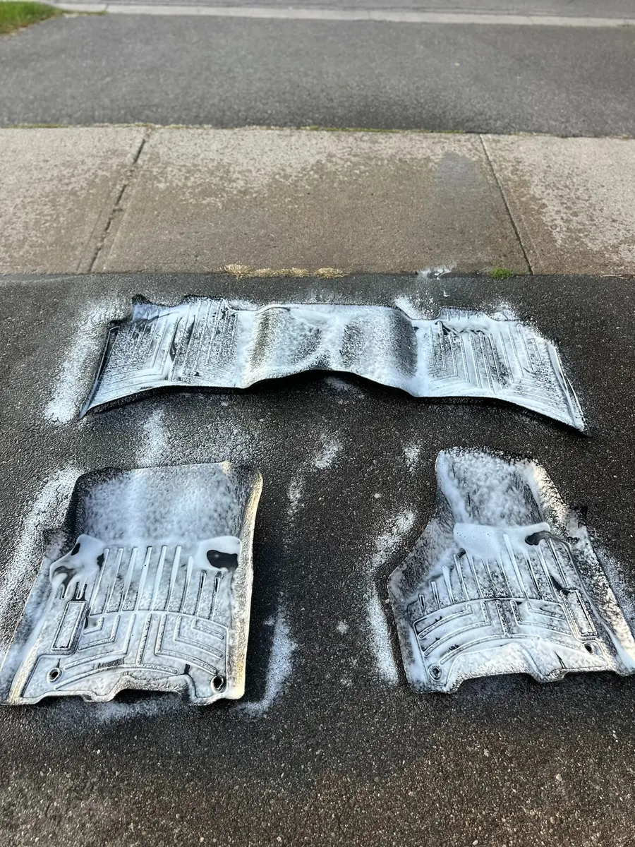 Vehicle floor mats being cleaned